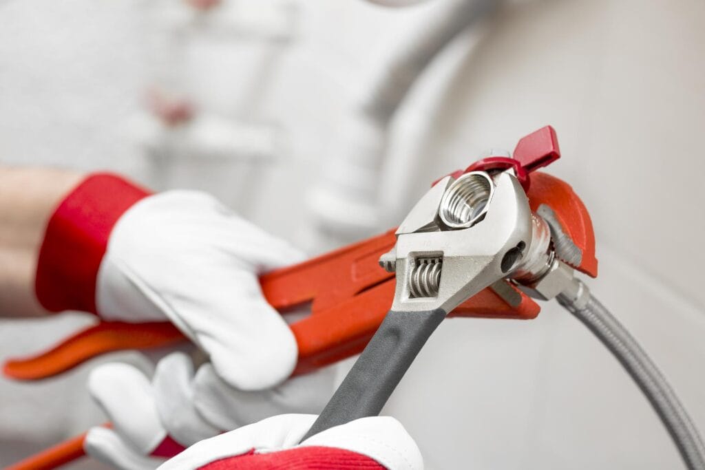 Plumber holding pipe wrenches for an emergency repair in Philadelphia